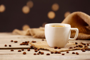 Cup of coffee on table on brown background