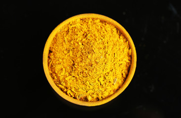 Curry in wooden bowl, isolated on black
