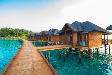 Fototapeta na wymiar Over water bungalows with steps into amazing green lagoon
