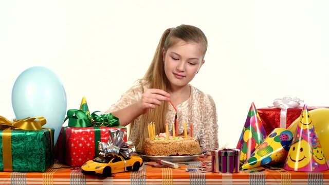 Girl sitting at banquet table. It is faced cake with candles