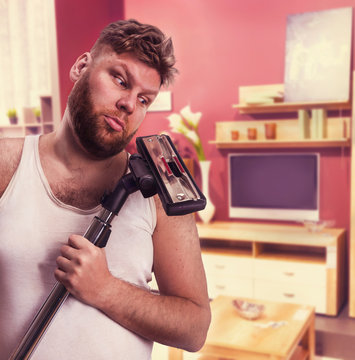 Adult Man Looks At The Vacuum Cleaner