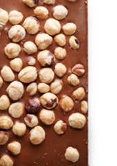 Milk chocolate bar with hazelnuts isolated on white