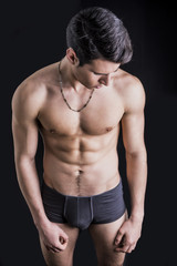 Fototapeta na wymiar Handsome, fit young man in underwear isolated on black