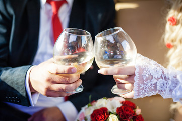 Wineglasses in hands of newlyweds