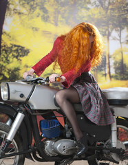 Fototapeta na wymiar Redhead girl on motorbike