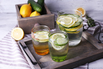 Fresh water with lemon and cucumber in glassware in wooden