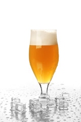 Glass of beer with foam and ice cubes isolated on white