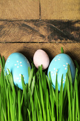 Easter eggs and grass on wooden background