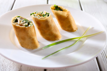 Pancakes with cream, cheese and greens in plate