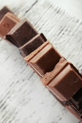 Squared chocolate on wooden table, top view