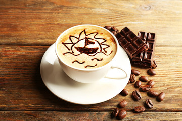 Cup of latte art coffee with grains and bar of chocolate