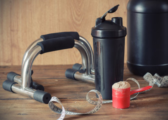 Whey protein powder in scoop and plastic shaker