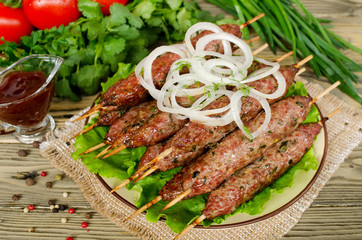 Grilled kebabs on wooden skewers and fresh vegetables