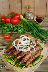 Grilled kebabs on wooden skewers and fresh vegetables