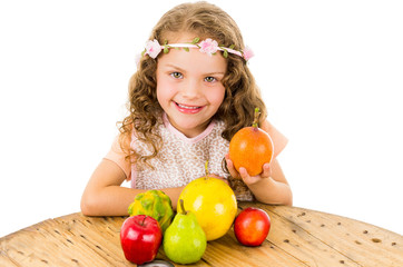 Fototapeta na wymiar Cute little preschooler girl with fruits on the table
