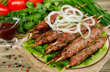 Grilled kebabs on wooden skewers and fresh vegetables