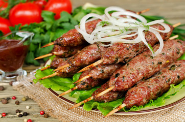 Grilled kebabs on wooden skewers and fresh vegetables
