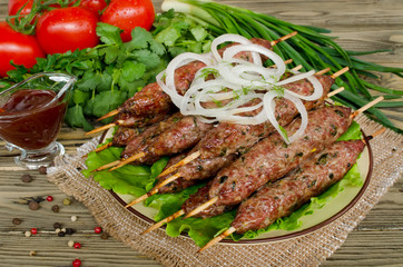 Grilled kebabs on wooden skewers and fresh vegetables