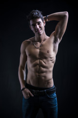 Fototapeta na wymiar Handsome muscular shirtless young man standing smiling c