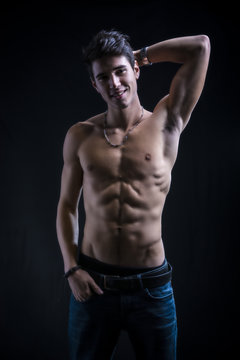 Handsome muscular shirtless young man standing smiling c