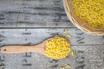 Italian Macaroni Pasta on basketwork with wooden texture backgro