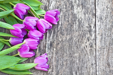 bouquet of violet tulips on the oak brown table