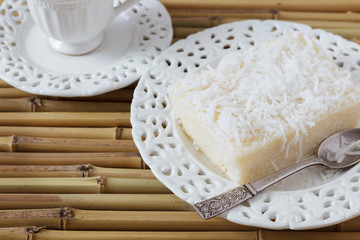 Sweet couscous pudding (cuscuz doce) coconut on vintage plate