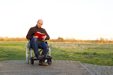 young man in a wheelchair reading a book