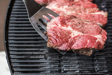 Beef steaks on grill or BBQ with spatula