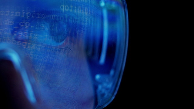 Closeup of glasses wearing men looking into a monitor.