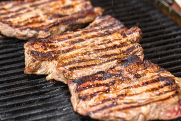 Beef steaks on grill or BBQ with spatula