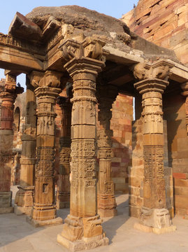 Columns with stone carving in courtyard of Quwwat-Ul-Islam mosqu