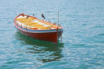 Wooden red boat in a calm lake