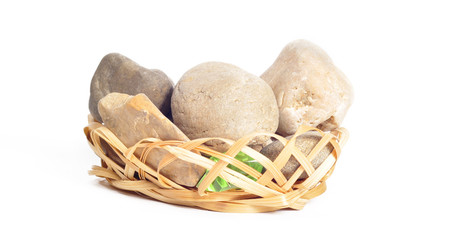 Stones in a wicker basket on a white background