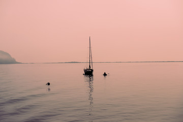 A small boat in a beautiful pink sunset - 80646714
