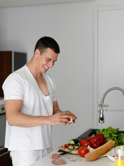 man cooking at home preparing salad in kitchen