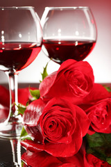 Composition with red wine in glasses, red rose and decorative