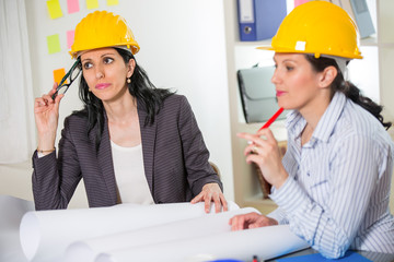 Architects working in office on construction project. 