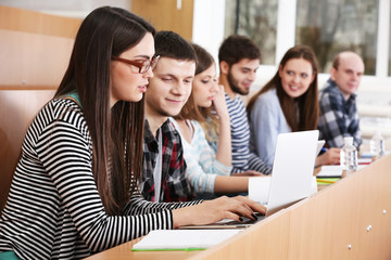 Group of students using gadgets in classroom