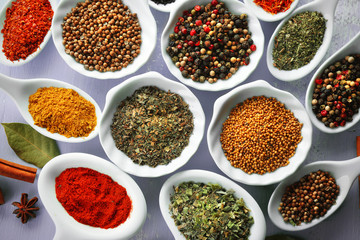 Different kinds of spices in ceramics spoons, close-up,