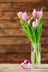 Beautiful pink tulips with decorative heart on wooden