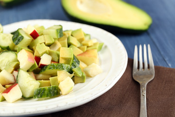 Salad with apple and avocado in bowl on table close up
