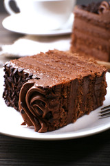 Tasty pieces of chocolate cake on wooden table background
