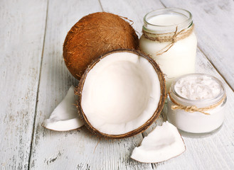 Fresh coconut oil in glassware on color wooden table background