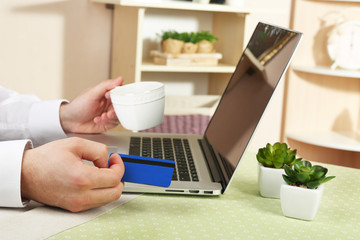 Man holding credit card and working