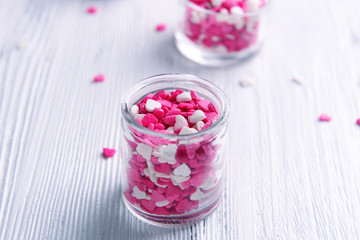 Colorful sprinkles in bowls on table close-up