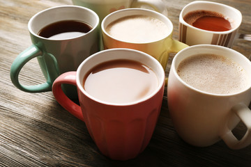 Many cups of coffee on wooden table, closeup