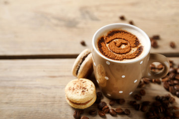 Cup of coffee  and macaroons on old wooden table