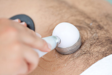 Acercamiento de las manos de una doctora llevando a cabo un tratamiento de ultrasonido en el...