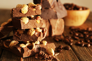 Stack of chocolate with nuts on wooden table, closeup